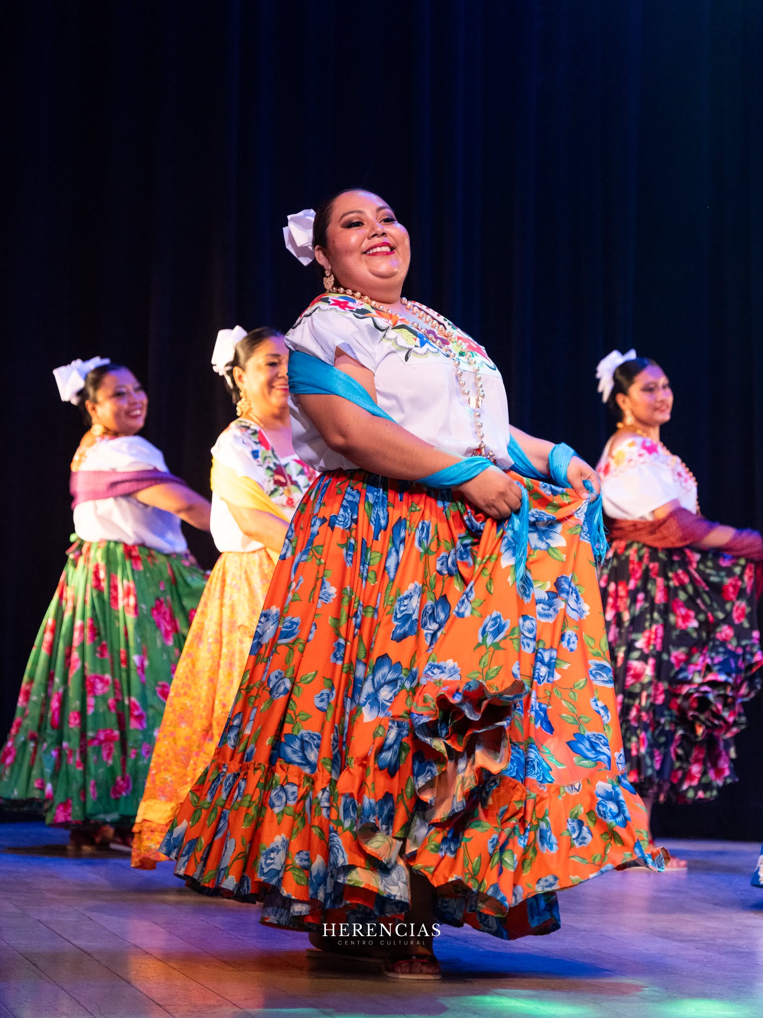 Integrantes de Sandungueras bailando con faldas coloridas